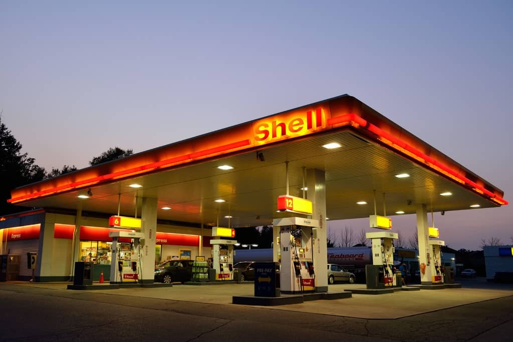 Shell gas station and convenience store with lights on at dusk