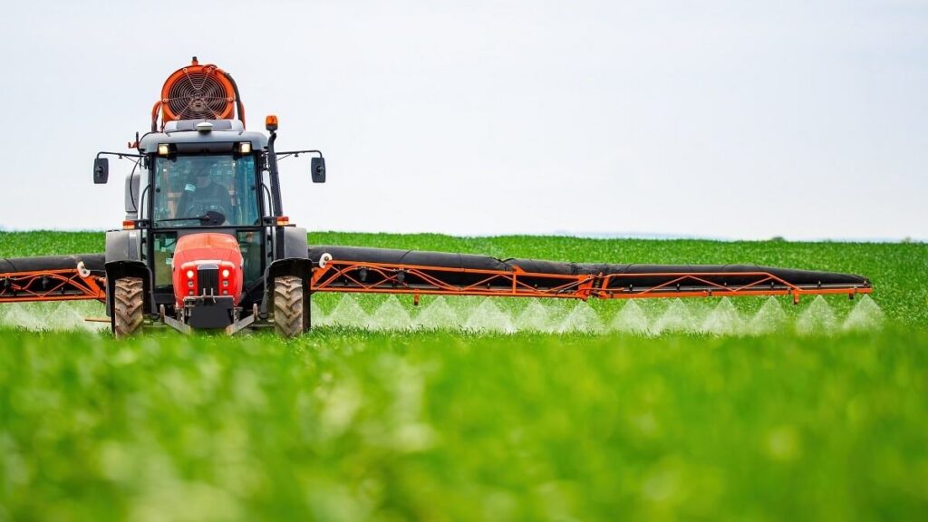 Tractor applying crop protection chemicals in field